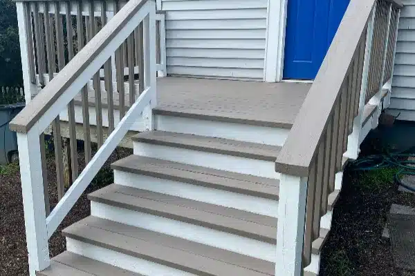 After: A set of six wooden steps leading up to a house with a blue door and railing on either side.